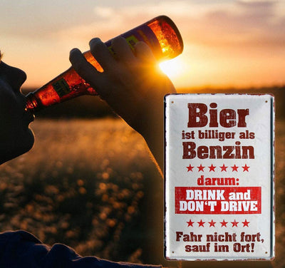 Blechschilder mit witzigem Spruch "Bier ist billiger als Benzin" von schilderkreis24. Das Schild zeigt einen Mann, der bei Sonnenuntergang Bier trinkt und ermahnt, nicht zu fahren. Ideal als Geschenkidee mit persönlicher Note.