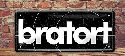 Blechschild mit markanter Aufschrift "Bratort" auf Backsteinwand platziert