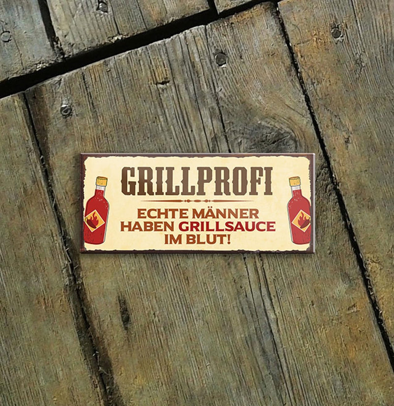 Grillprofi - Lustiger Spruch auf einem Blechschild, das Echte Männer Grillsauce im Blut haben, anzeigt. Das Produkt ist vor einem Holzuntergrund platziert.