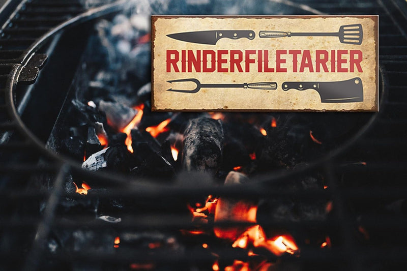 Lustiger Grill-Spruch "Rinderfiletarier" auf einem Holzschild, das über einem Feuer mit glühenden Holzkohlen schwebt. Das Schild dient als Dekor und Geschenkidee für Fleischliebhaber.