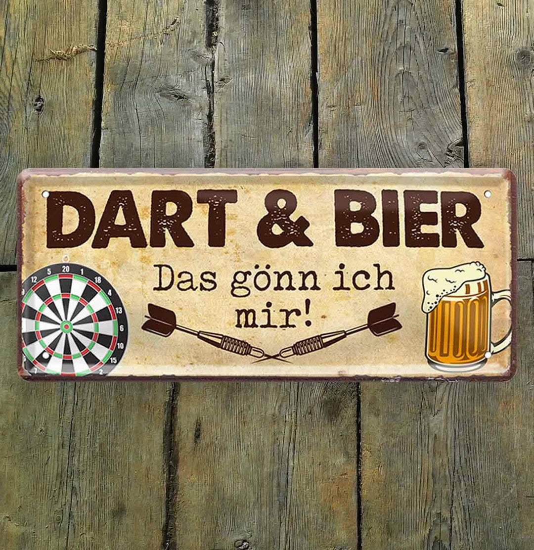 Blechschild mit lustigem Spruch "Dart & Bier das gönn ich mir!" 28x12 cm. Das Schild zeigt eine Dartscheibe und ein Bierglas als Symbole für ein gemütliches Zusammensein bei einem Getränk und etwas Sport. Es ist ein personalisiertes Geschenk, das ideal für Geburtstage, Muttertage oder andere Anlässe bei schilderkreis24 erhältlich ist.